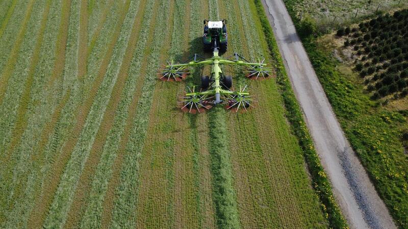 Vue aérienne tracteur Fendt Taserag avec andaineur Claas en prairie