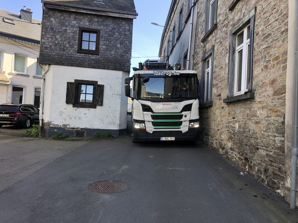 Camion Scania Taserag manœuvrant dans une ruelle étroite en milieu urbain